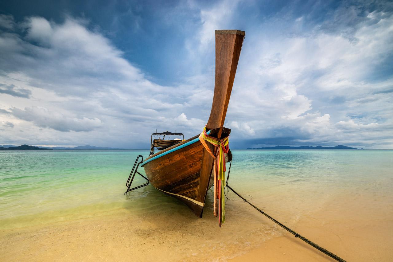Long-tail boat at the beautiful Koh Kradan beach on a stormy day