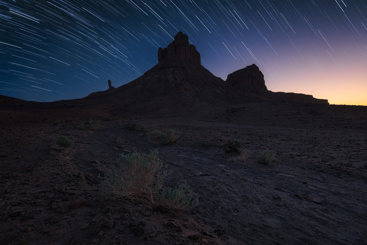 Star Trails above jagged peaks in the desert.