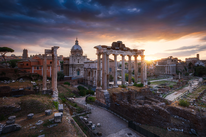 The sun rises behind the ruins of the Forum Romanum