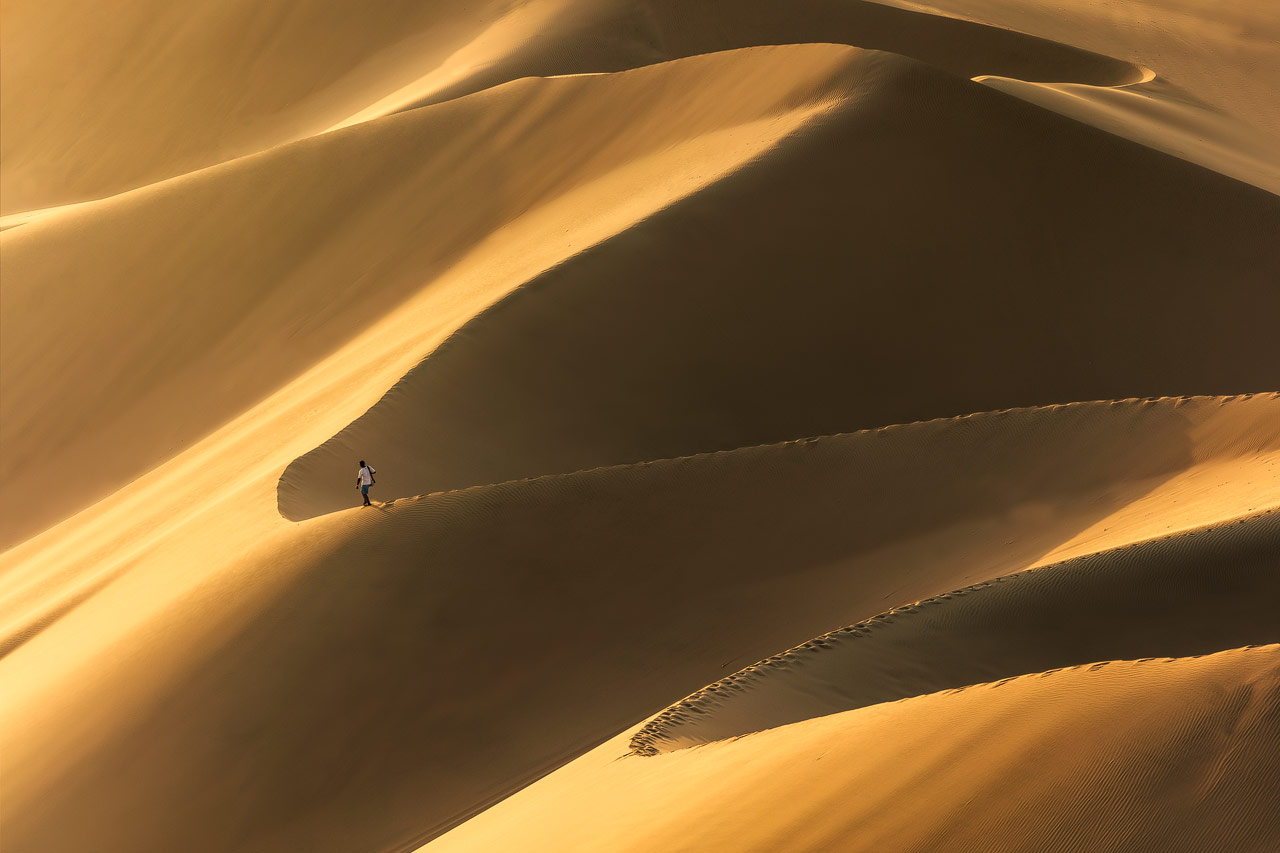 Person walking along the massive dunes of Huacachina