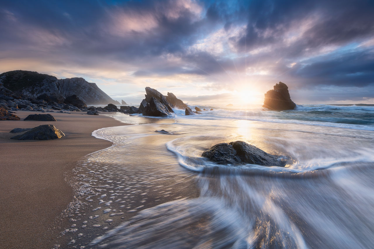 Intense sunset at the rocky Praia da Adraga beach