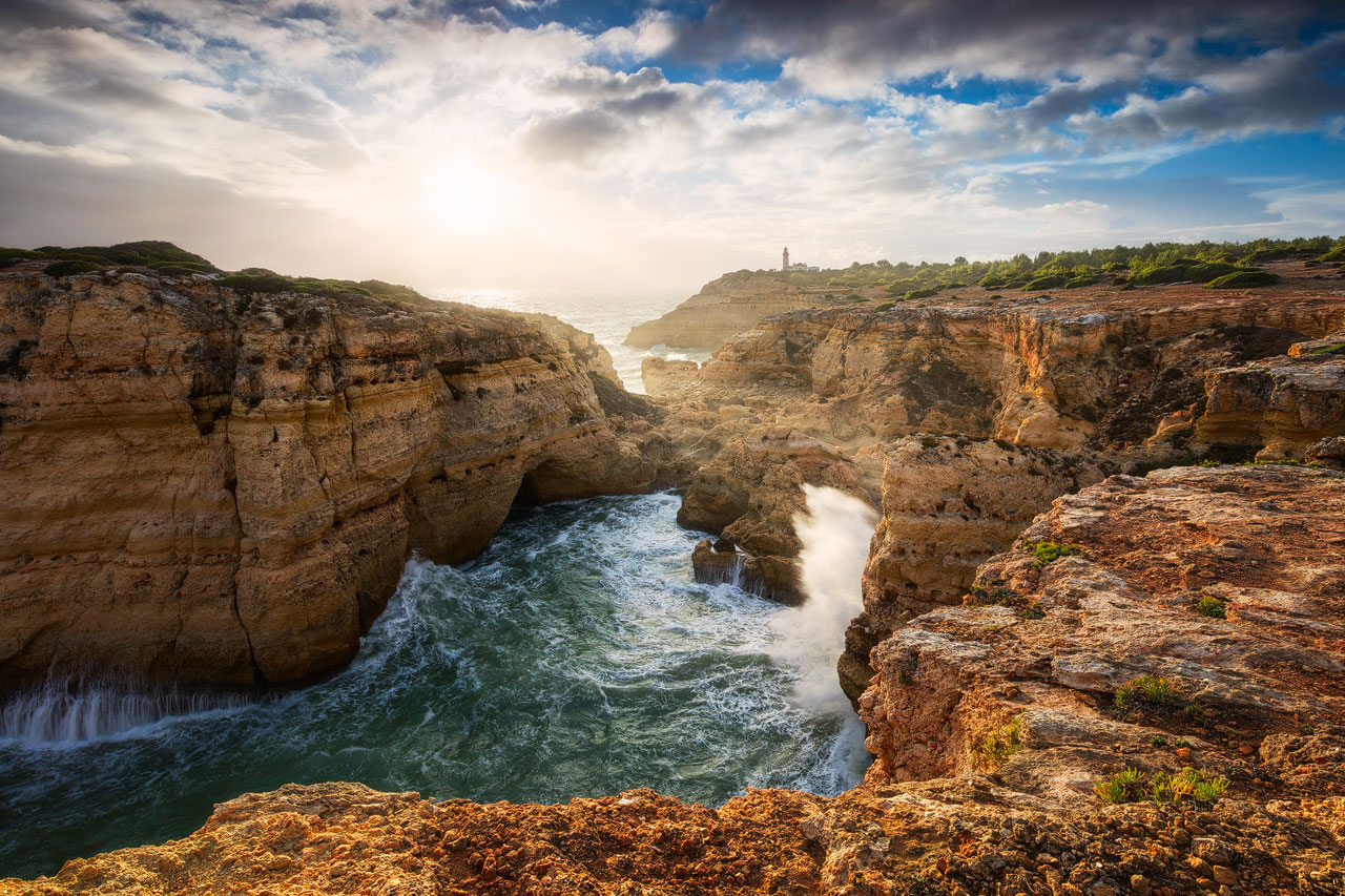 Enormous waves crashing on the rocks near Alfanzina Lighthouse at the Algarve