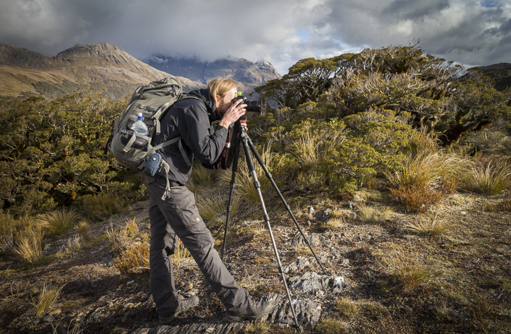 A photographer in front of some mountain landscape in New Zealand