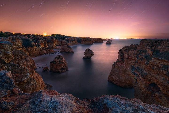 Startrails and a glowing city at the algarve