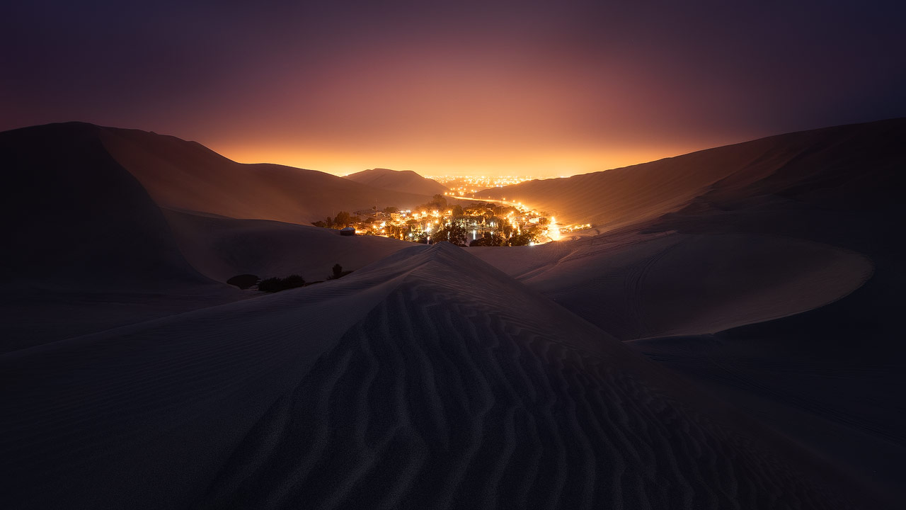 Huacachina glows in the night, surrounded by dunes