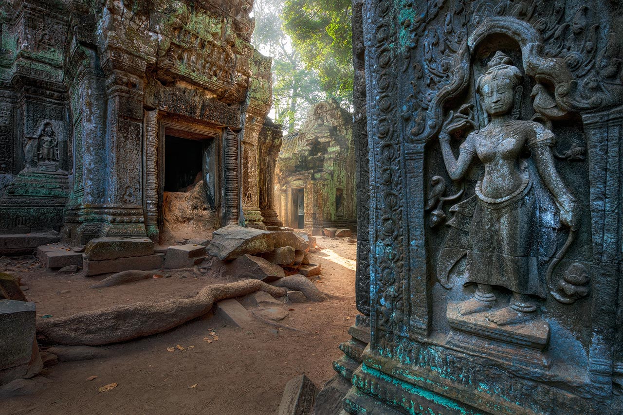 Relief of Apsara dancer with view of Ta Prohm temple grounds