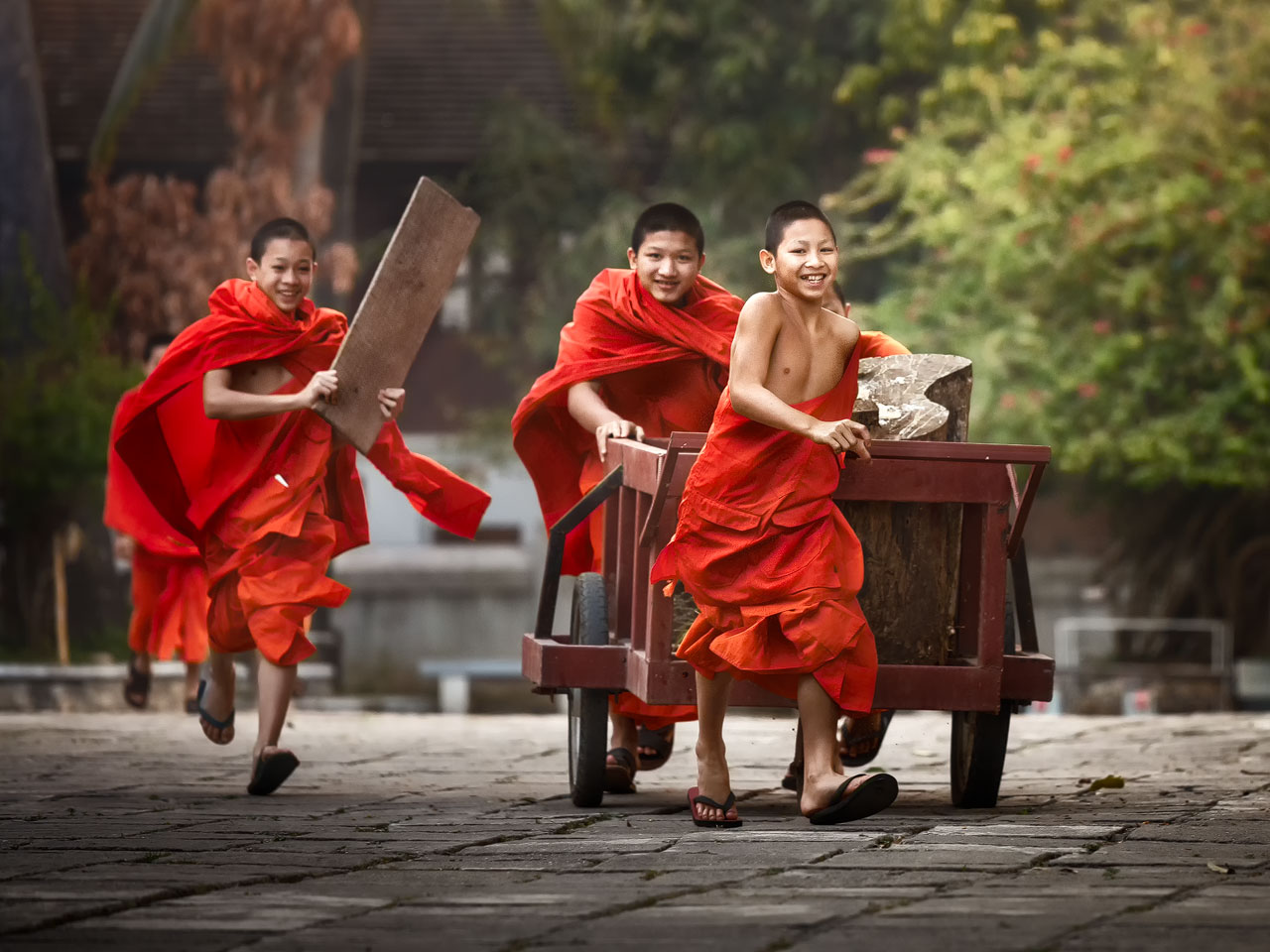 Spielende junge Mönche in einem Tempel in Luang Prabang