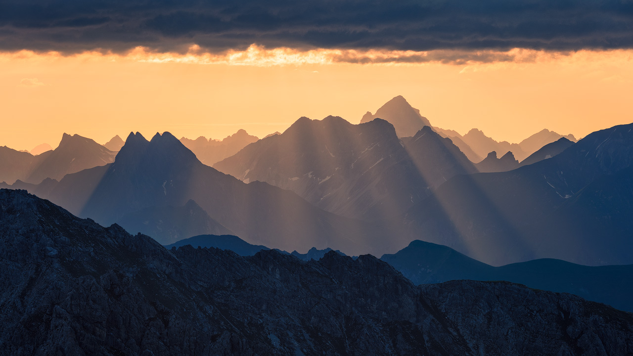 Sunrays light up the mountains of the Allgäu Alps.