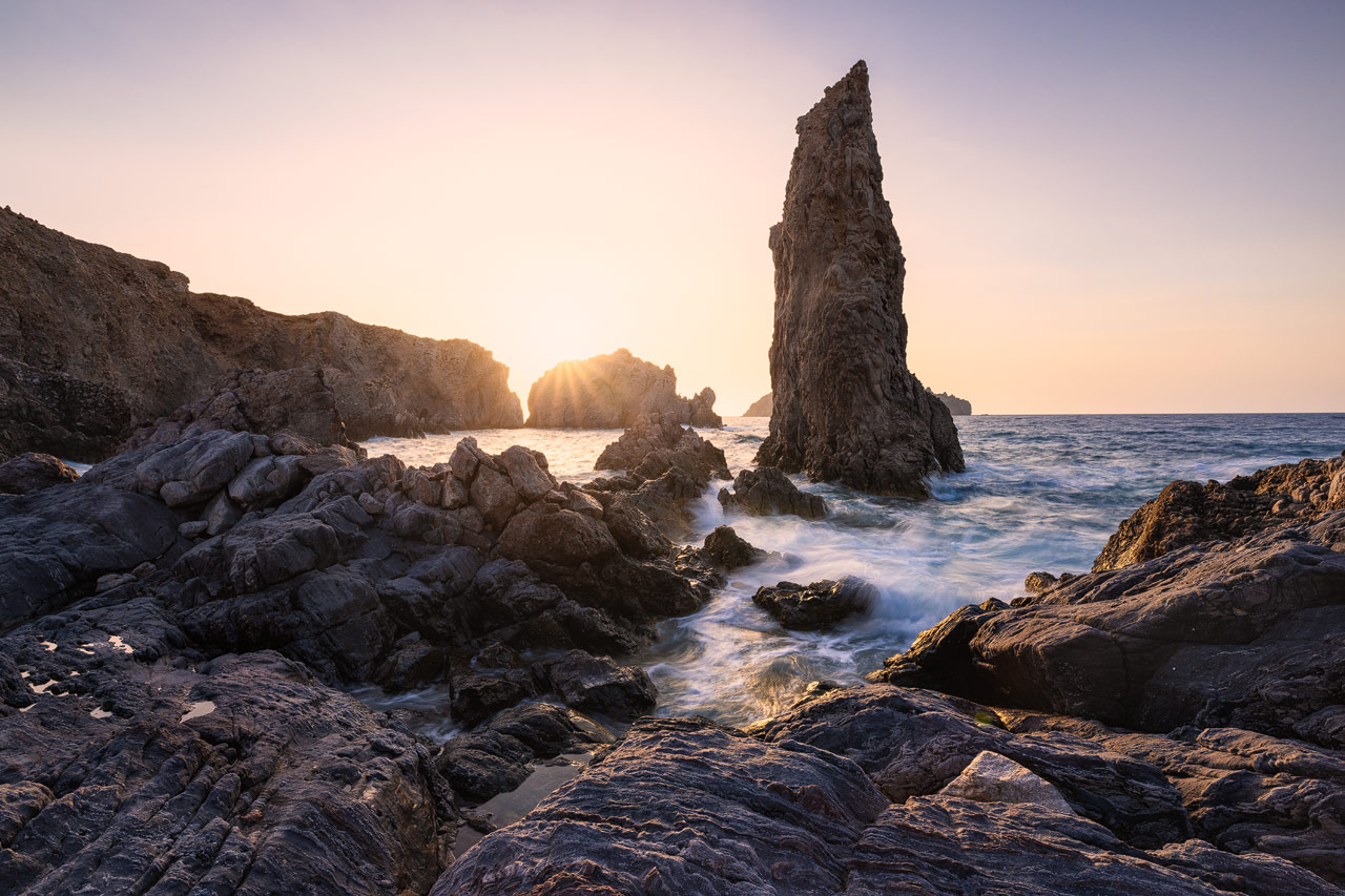 Ein gewaltiger Fels ragt aus dem Wasser vor der Küste von Milos, Griechenland