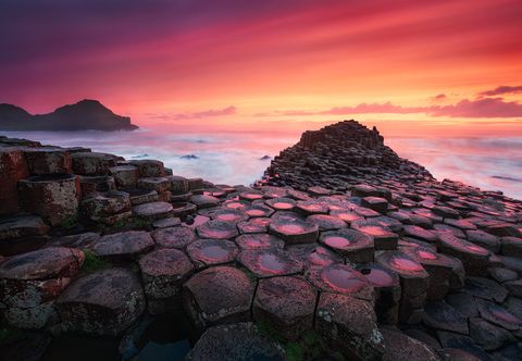 Giant's Causeway hexagonal basalt columns by the sea at sunset in Northern Ireland.