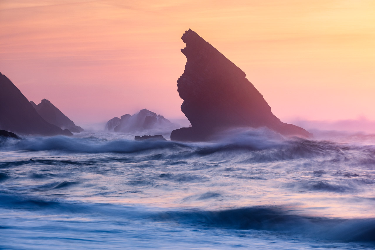 A rock shaped by the sea at Praia da Adraga at dusk
