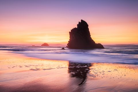 Einer der charakteristischen Felsen am Praia da Adraga nach Sonnenuntergang.