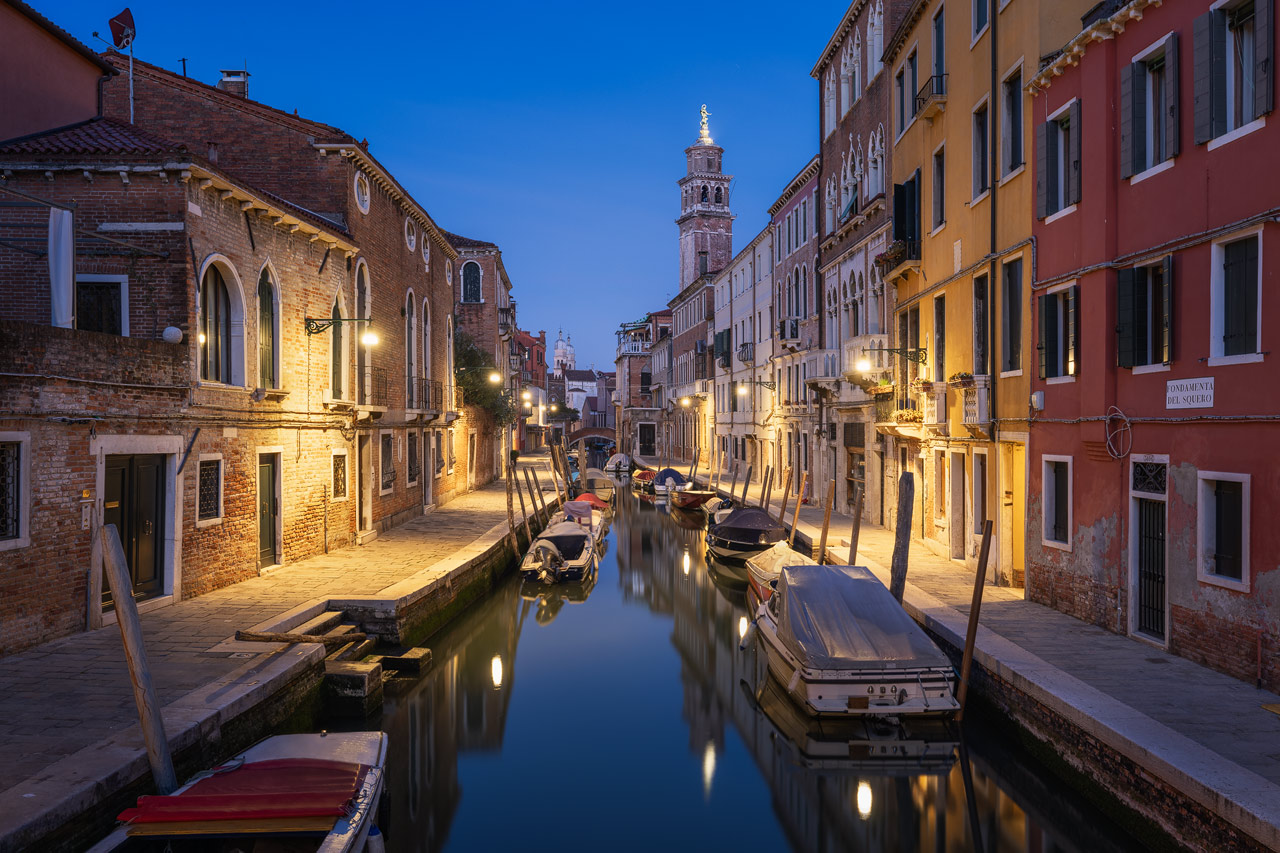 Ein Kanal mit Booten im Dorsoduro Bezirk von Venedig zur Blauen Stunde.