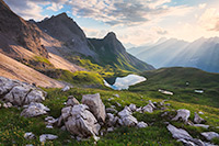 Sunlight filters through the clouds to bath this mountain scene in ethereal light