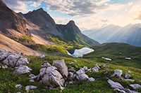 Sunlight filters through the clouds to bath this mountain scene in ethereal light