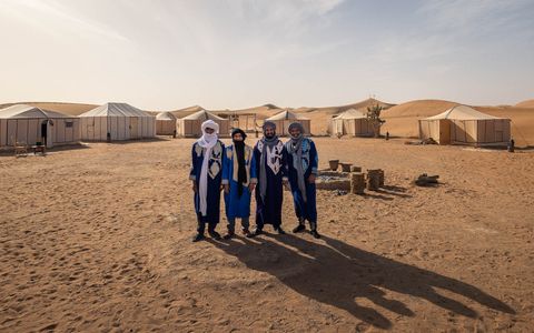 The Crew of Camp Al Coutban posing in the desert.